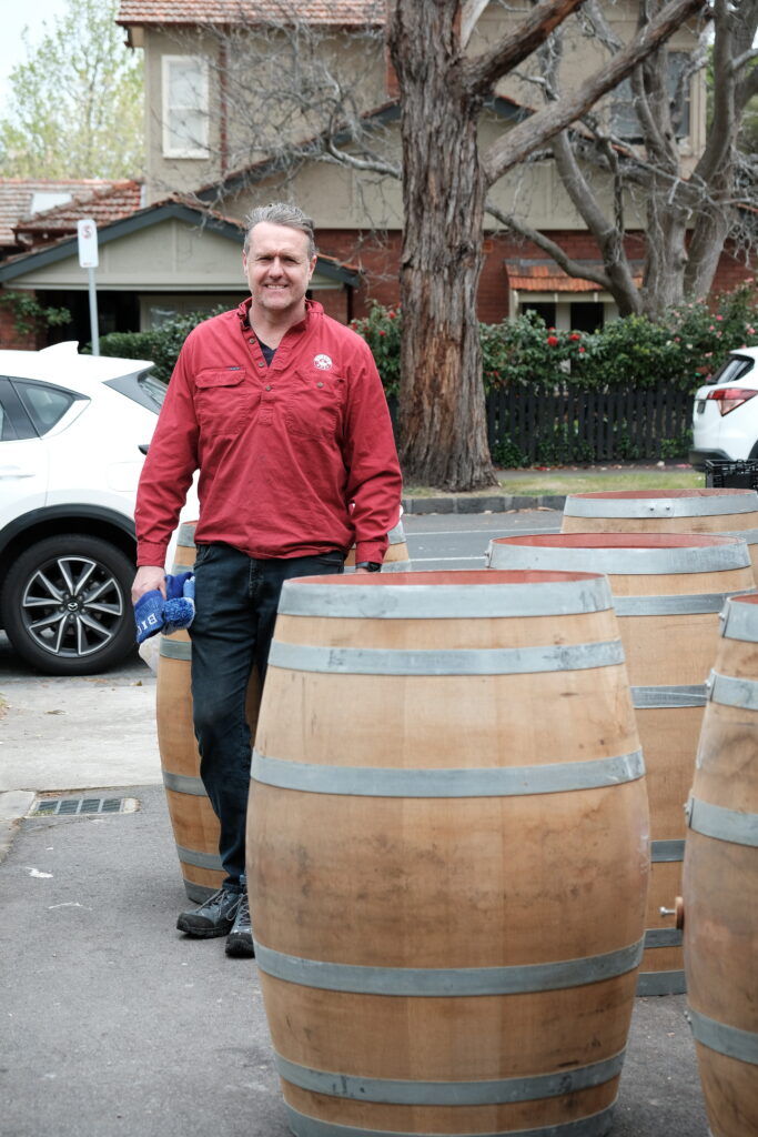 Full wine barrels stacked neatly for repurposing into wooden hot tubs or wine barrel ice baths
