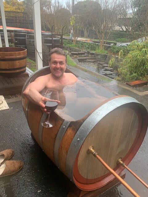 Colin enjoying a wine and a hot bath in french oak barrel